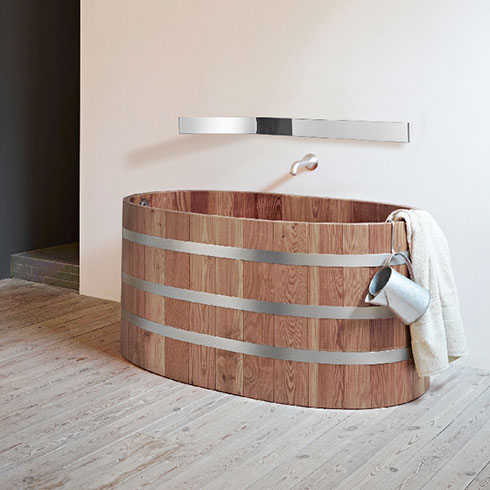 thin strip curved bathroom mirror hanging above wooden bath tub