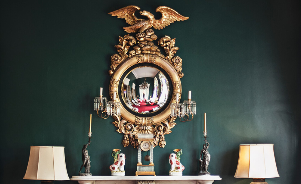 ornate gold mirror on dark green wall - luxurious style living room