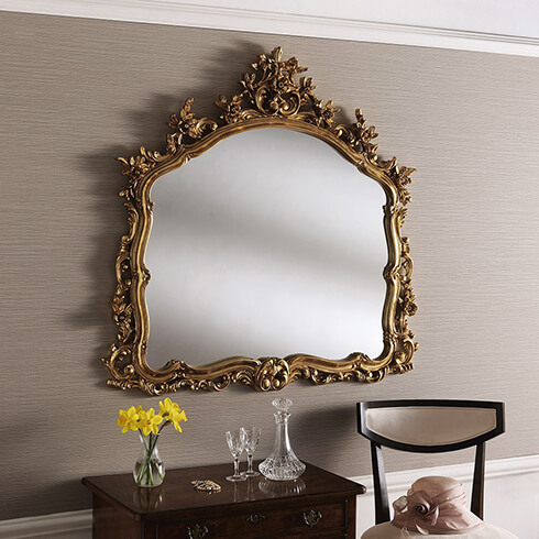 traditional style large ornate framed crested gold mirror on wall
