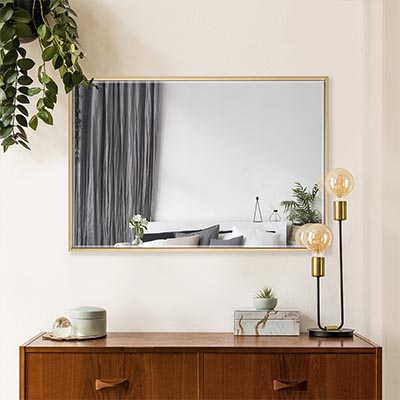 modern gold framed custom sized mirror on wall above cupboard