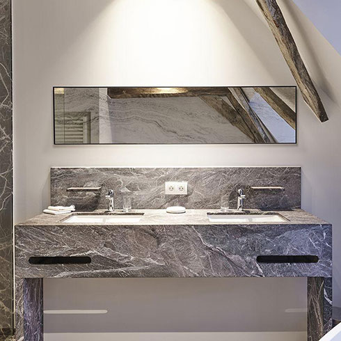 slim horizontal rectangular bathroom mirror with thin black frame and stone printed effect hanging above grey marble sink