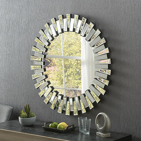 sun burst round multi facet art deco mirror on grey wall above sideboard