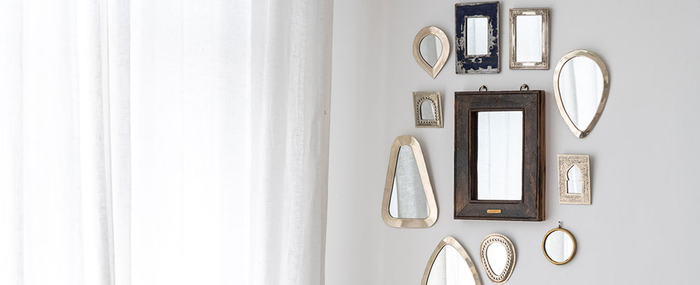 collection of framed mirrors hanging on white wall