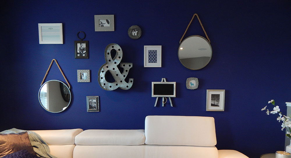 multiple circular mirrors and picture frames hanging on feature wall in living room